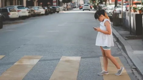 Niña distraída con smartphone