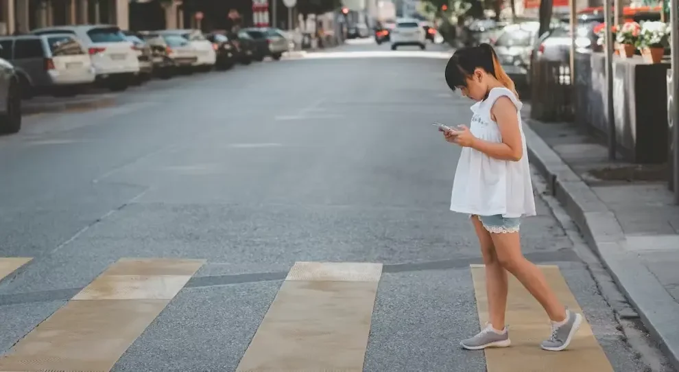 Niña distraída con smartphone