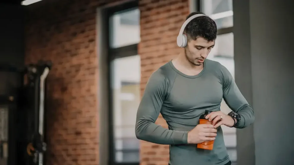 Hombre tomando agua gimnasio