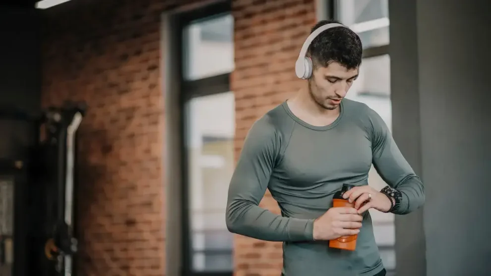 Hombre tomando agua gimnasio