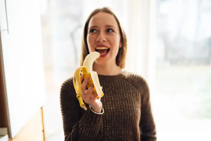 Mujer comiendo plátano