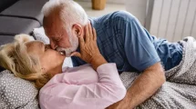 Pareja mayor besándose en la cama